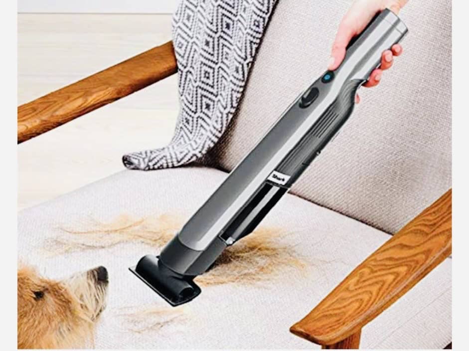 Shark handheld vacuum vacuuming dog fur from which couch in front of orange dog. Click on picture link to purchase online.